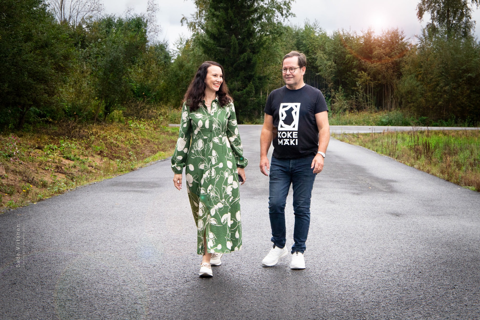 Johanna Rantalainen ja Juhani Seppälä kävelevät tiellä metsäisessä puistossa.